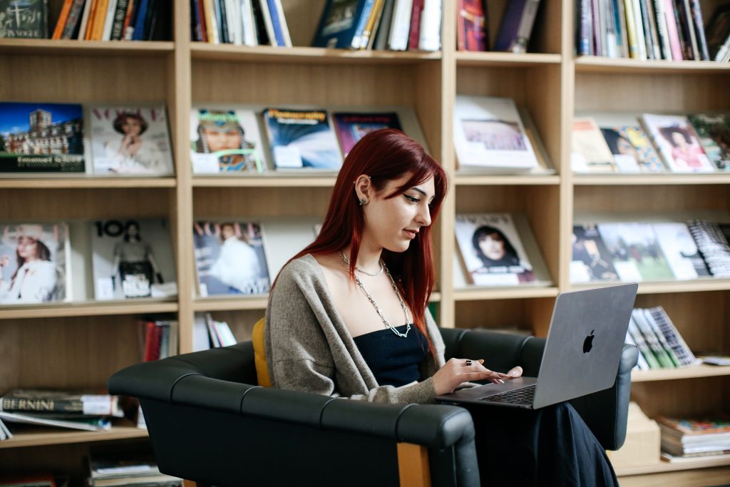 Student in a libaray working on a laptop