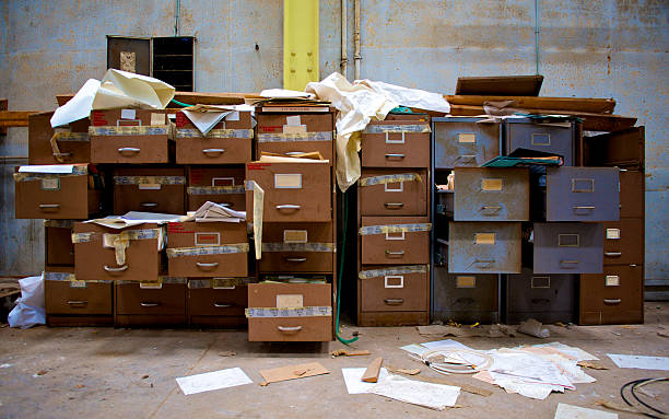 Disorganised filing cabinets with paper every where system