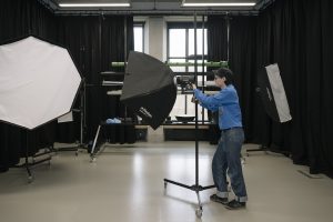 Student moving equipment in studio